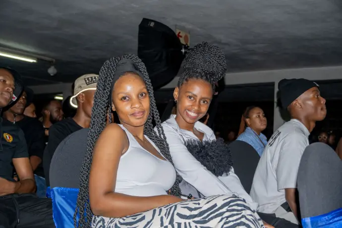 Student smiling and posing with friends at a vibrant Res Life social event at Burgers Park Student Hotel