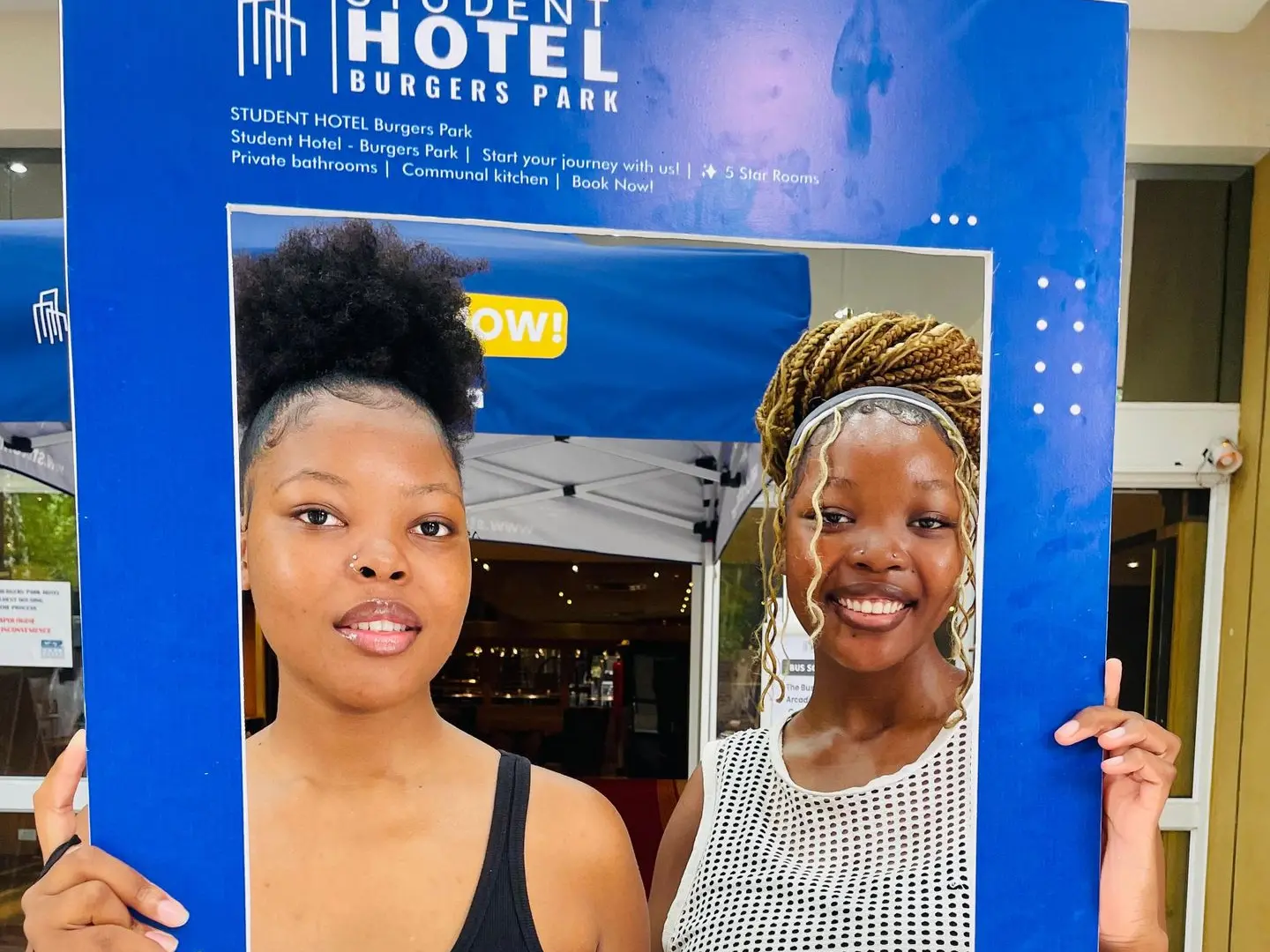 wo female students smiling inside a Res Life photo frame during an event at BPSH