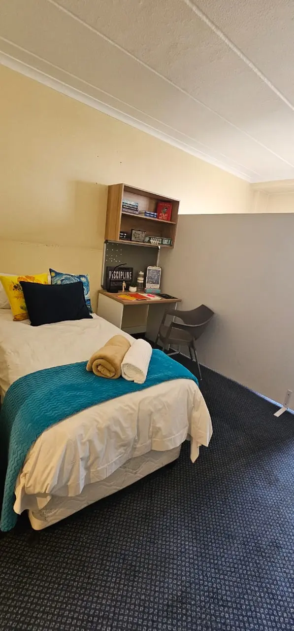 Two-sharing student room with divider and study desks at BPSH
