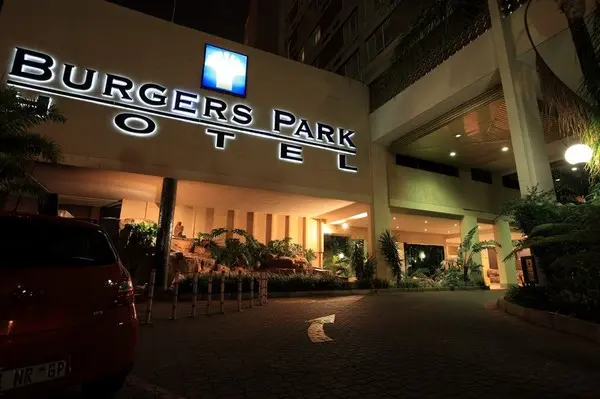 Night view of the former Burgers Park Hotel entrance with signage and lighting