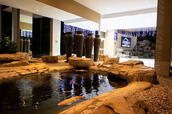 Covered hotel entrance with tall columns and decorative lighting at Burgers Park