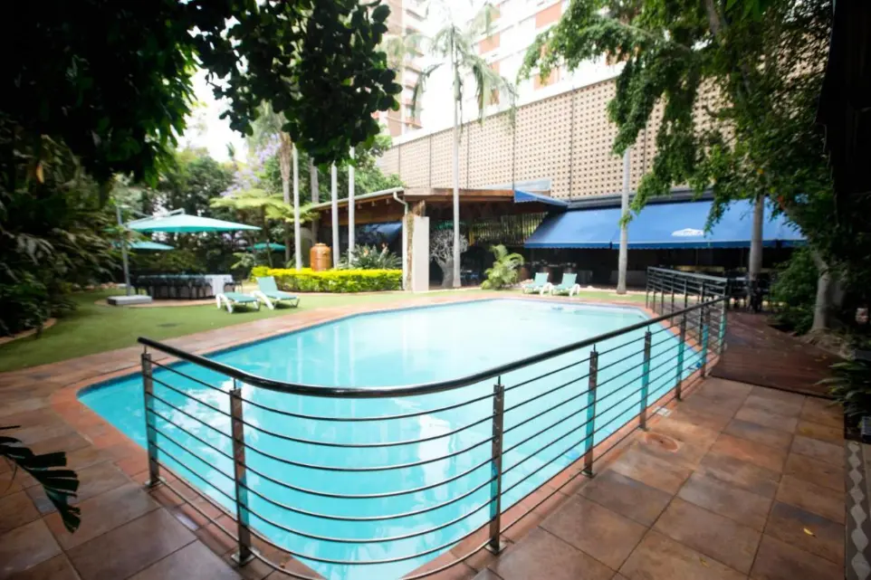 Outdoor pool area with seating and railings at Burgers Park Hotel before renovation